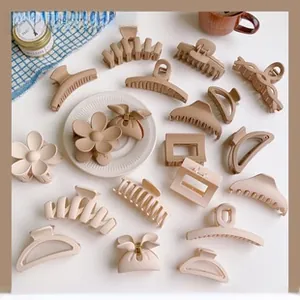 Detailed top view of matte hair clips in cream and brown colors on a white table