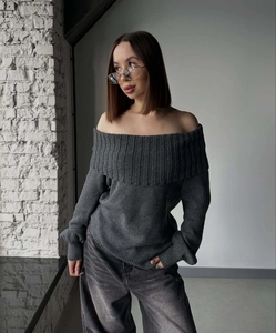 Close-up of dark grey off-shoulder knit sweater with detailed texture on a female model