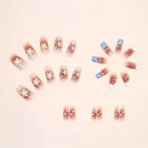 Cute gradient blush press-on nails with floral, star and heart designs in coffin shape