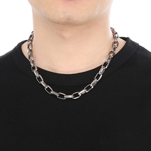 Close-up of a silver cuban chain necklace with rectangular links on a male model
