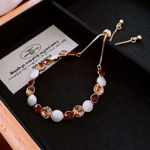 Detail of adjustable gold bracelet with colorful crystals and pearls on jewelry box