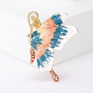 Detailed macro view of enamel butterfly brooch with blue and pink wings and shiny rhinestones