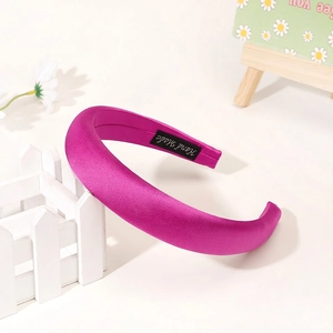Detail of rose red padded headband with handmade label and smooth satin texture