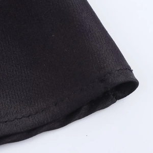 Detailed macro view of black satin dress fabric showing twill weave and stitched hem finish