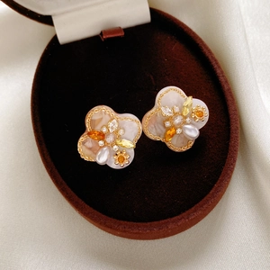 Macro shot of vintage floral earrings with pearls and amber crystals in a jewelry box