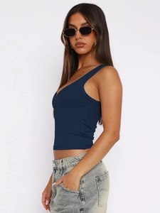 Detailed side view of navy blue ribbed crop tank top on model with denim jeans