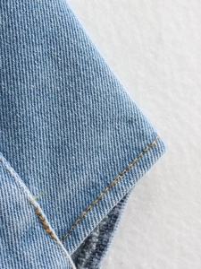 Vue macro de la texture du denim bleu clair avec coutures contrastées détaillées