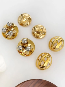Macro shot of vintage gold-plated semi-circle earrings with hollow texture details