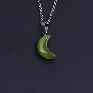 Vue détaillée du pendentif lune verte avec effet oeil de chat sur chaîne argentée