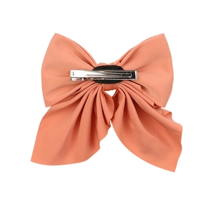 Detail of coral pink bow hair clip back view with secure silver metal duckbill fastener