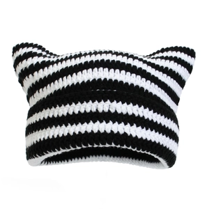 Close-up detail of a handmade black and white striped knitted cat ear beanie cap
