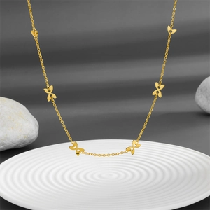 Collier élégant avec pendentif papillon doré en acier inoxydable sur plateau blanc