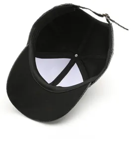 Detail view of the black baseball cap showing the interior canvas lining and metal buckle