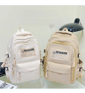 Detailed view of functional multi-pocket backpack with side buckles and logo patch
