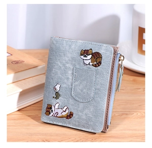 Close-up of light blue leather wallet featuring a cute cat embroidery and gold zipper