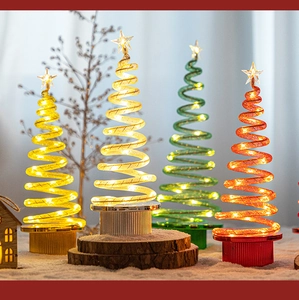 Close-up of four colorful spiral LED mini Christmas trees with warm glowing stars
