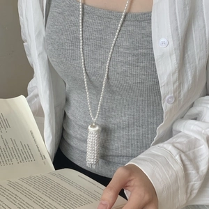 Detail of long pearl tassel necklace featuring multi-strand drop on a stylish model