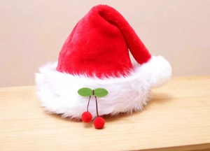 Detail of plush Christmas hat with white faux fur trim and cherry pompom accents