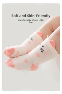 Close-up of white baby non-slip cotton socks with cute cartoon cat ears and pink dots