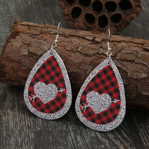 Teardrop red buffalo plaid leather earrings featuring heart design on rustic background