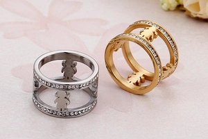 Close-up of dual-layer stainless steel rings with hollow figure and pave stones