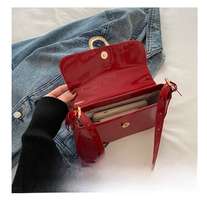 Detailed interior of red patent leather shoulder bag showing smartphone storage capacity