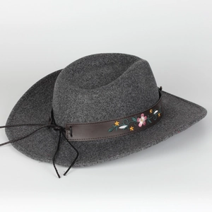 Detail of dark grey felt fedora featuring leather band with floral embroidery and Western style
