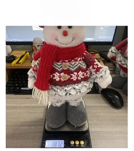 Detailed view of plush Christmas snowman on digital scale weighing 381.2 grams