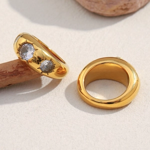 Macro detail of 18K gold plated wide ring with two sparkling round cubic zirconia stones