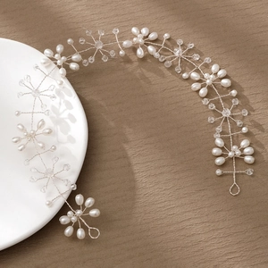Detailed close-up of handmade bridal hair vine with white pearls and crystals on silver wire