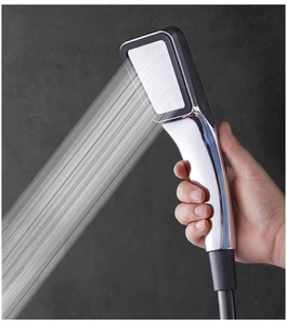 Close-up of hand-held square chrome shower head spraying 300 dense water streams