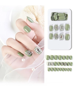 Macro view of 24pcs avocado green press-on nails with pearls and rhinestone accents