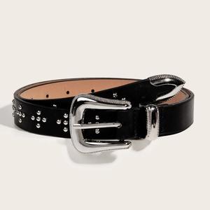Détail d'une ceinture en cuir noir vintage avec boucle florale argentée et rivets décoratifs