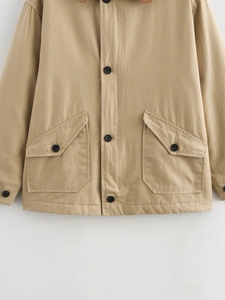 Detail of khaki cotton jacket showing corduroy collar and buttoned pockets texture