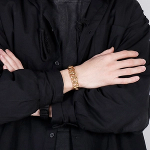 Polished gold Cuban link bracelet for men on wrist with high-end aesthetic