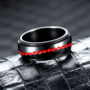 Detail of a rotating black stainless steel ring featuring unique red zigzag patterns