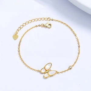 Detail of gold butterfly bracelet with shell inlay and adjustable heart charm chain