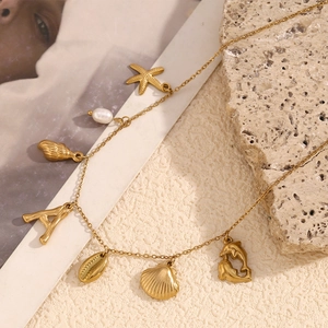 Detailed close-up of 18K gold plated ocean pendants featuring starfish and shell