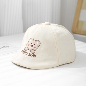 Détail du béret bébé beige avec broderie ours et texture en coton sergé doux