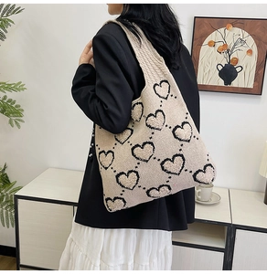 Détail du sac fourre-tout tricoté beige avec motifs de cœurs en peluche et bandoulière