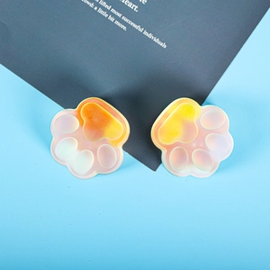 Close-up of cat claw charms with orange gradient finish and pearlescent texture