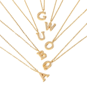 Gold letter pendant necklaces with sparkling zircon crystals in a radiating layout