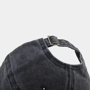 Detail of the vintage washed cotton cap with bronze metal buckle and adjustable strap