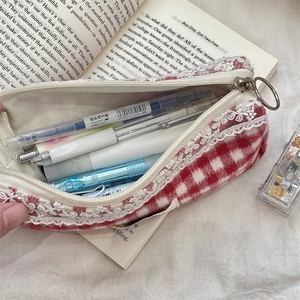 Close-up of red plaid knit pouch with white lace trim and large storage capacity