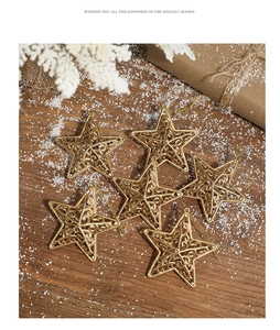 Set of 6 gold hollow star ornaments on a rustic wooden table with artificial snow