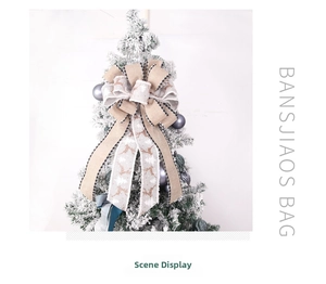 Detail of burlap Christmas tree topper bow with reindeer pattern and plaid edges