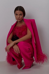 Detail of pink suit set featuring ostrich feather trim and matching silk high heels