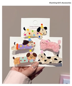 Close-up of five cartoon dog and cat hair clips with marble texture on a white display card