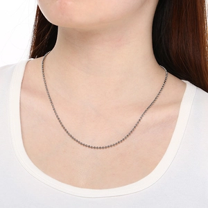 Collier minimaliste à billes en acier inoxydable porté par un mannequin en t-shirt