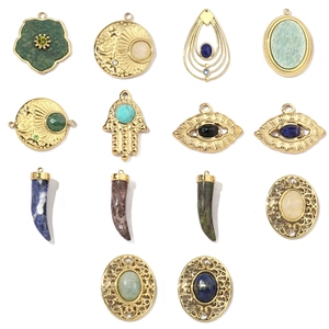Detailed view of assorted gold stainless steel charms with celestial and boho gemstone motifs